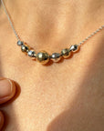 Necklace with gold and silver beads on a person's neck
