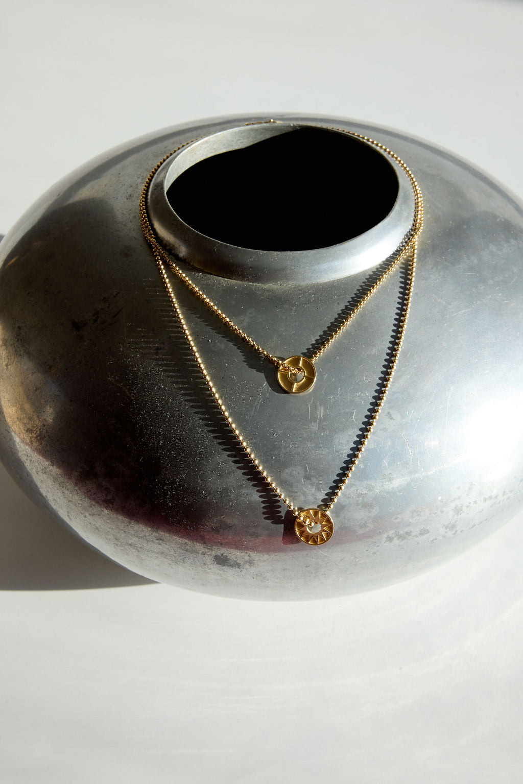 Still life of necklaces on a silver vase