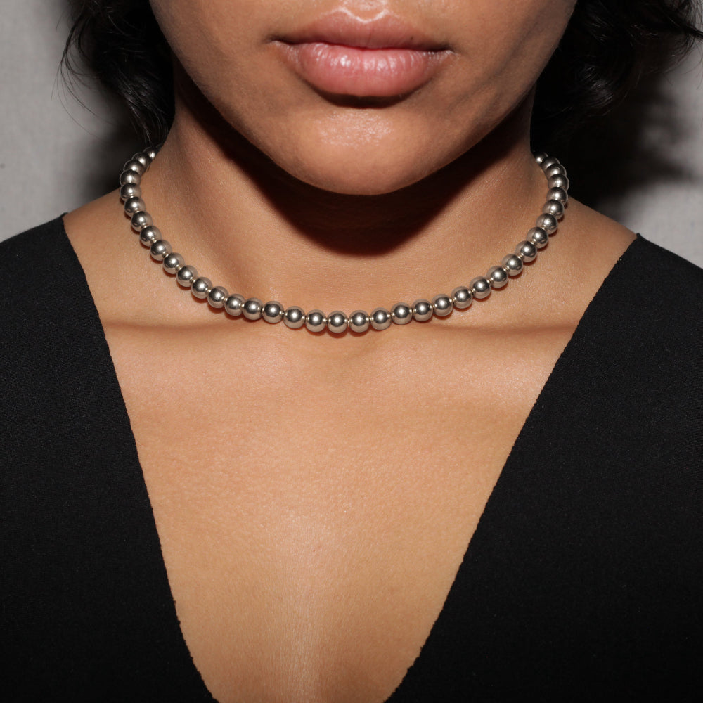 silver bead necklace on woman wearing black tank